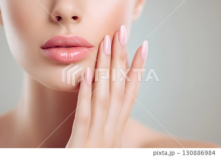 美しい女性の口元と手。ピンクのネイルと艶やかな唇を強調した美容コンセプトのクローズアップ 130886984