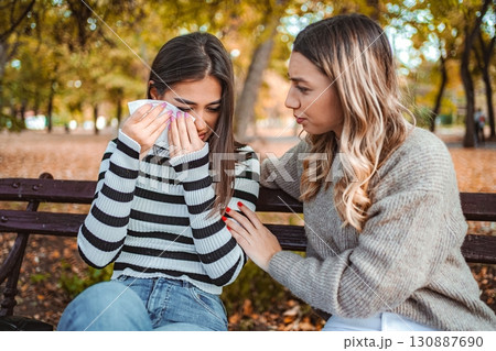Friends share an emotional moment in a beautiful autumn park scene Friends share an emotional moment in a beautiful autumn park scene 130887690