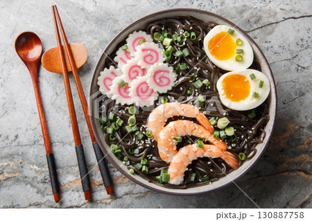 Tasty boiled Soba noodles with shrimp, narutomaki, green onion and egg close-up in a bowl. Horizontal top view 130887758