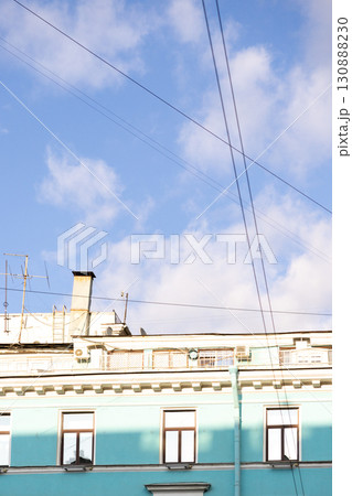 Urban life, a house with blue walls after restoration. A blue sky with a few clouds. Urban life, a house with blue walls after restoration. A blue sky with a few clouds. 130888230