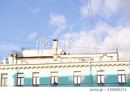 Urban life, a house with blue walls after restoration. A blue sky with a few clouds. Urban life, a house with blue walls after restoration. A blue sky with a few clouds. 130888231
