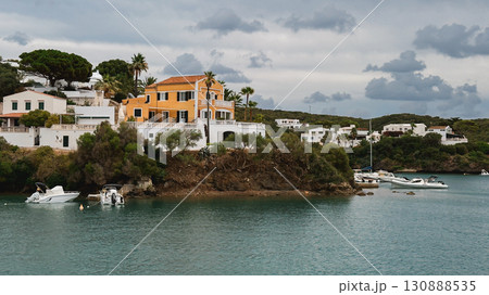 Coastal villa with orange walls and white details overlooking a calm bay. Menorca, Mahon Coastal villa with orange walls and white details overlooking a calm bay. Menorca, Mahon 130888535