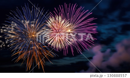 Colorful fireworks exploding in the dark night sky with trails of light and smoke. Celebration, holiday and festive event concept 130888557