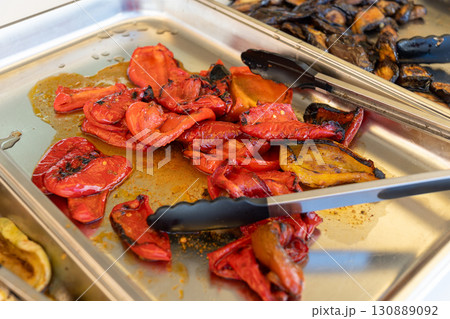 Baked bell peppers on a charcoal grill, served on a platter for a buffet. 130889092