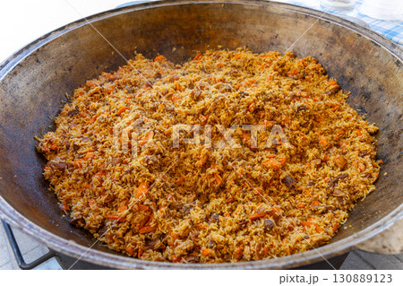 A large metal cauldron with freshly prepared Uzbek pilaf A large metal cauldron with freshly prepared Uzbek pilaf 130889123