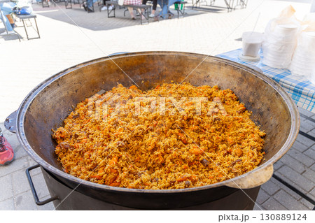 A large metal cauldron with freshly prepared Uzbek pilaf 130889124