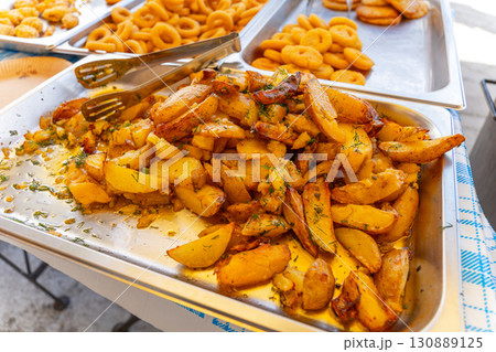 Trays of crispy fried onion rings, chicken nuggets, and French fries 130889125