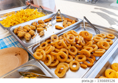Trays of crispy fried onion rings, chicken nuggets, and French fries 130889126