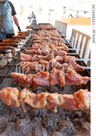Sizzling skewers of marinated meat grilling over hot coals Sizzling skewers of marinated meat grilling over hot coals 130889130