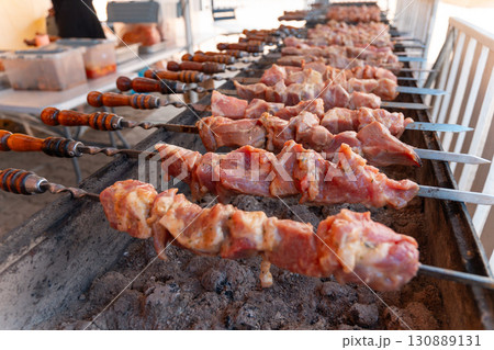 Sizzling skewers of marinated meat grilling over hot coals Sizzling skewers of marinated meat grilling over hot coals 130889131