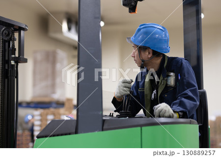 冷蔵倉庫でフォークリフトに乗る男性 130889257
