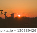 沈む夕日と街灯・ビル群のシルエット 130889426
