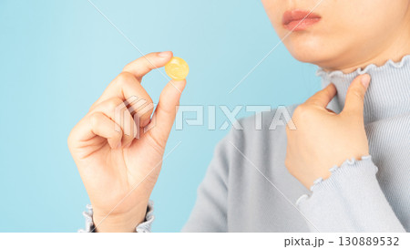 Woman taking medical lozenges with honey lemon flavored for relief sore throat, irritating cough and mouth pain. Close up of female feeling sick and cold over light blue backgroud. Health care. Woman taking medical lozenges with honey lemon flavored for relief sore throat, irritating cough and mouth pain. Close up of female feeling sick and cold over light blue backgroud. Health care. 130889532
