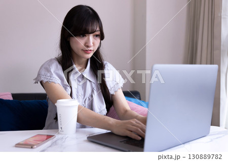 リビングでPC作業をする日本人女性 リビングでPC作業をする日本人女性 130889782