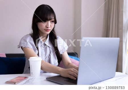 リビングでPC作業をする日本人女性 リビングでPC作業をする日本人女性 130889783