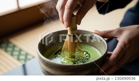 Traditional Japanese matcha tea preparation with bamboo whisk in ceramic bowl 130890036