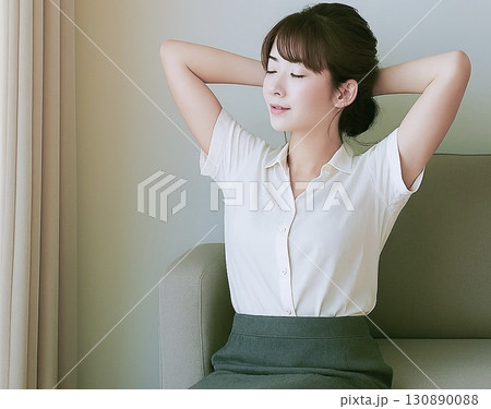両手を頭の後ろに組んでリラックスしている若い女性 130890088