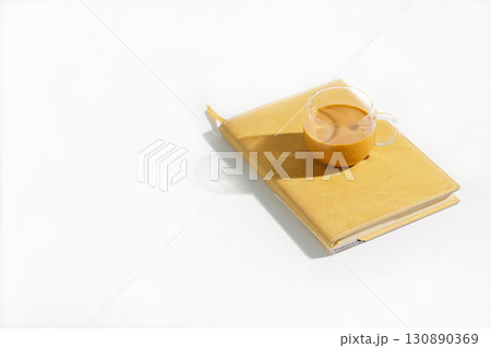 Thai iced tea placed on notebook on minimal white table under summer hard light 130890369