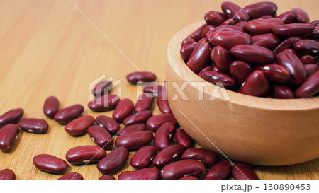 Red kidney beans in wooden bowl on wooden table 130890453