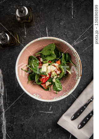 Spinach salad with salmon, almonds and vegetables Spinach salad with salmon, almonds and vegetables 130890899