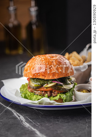 Tasty cheeseburger with fries, sauces and salad Tasty cheeseburger with fries, sauces and salad 130890929