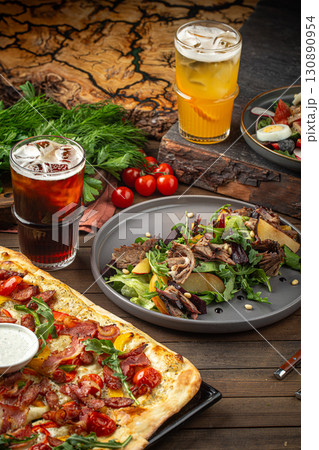Flatbread pizza and duck salad with refreshing drinks Flatbread pizza and duck salad with refreshing drinks 130890954