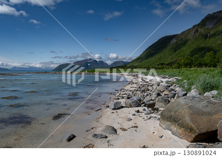 Coastal Landscape With White Sand Beach And Snowy Mountains At Fjord On Lofoten In Norway Coastal Landscape With White Sand Beach And Snowy Mountains At Fjord On Lofoten In Norway 130891024