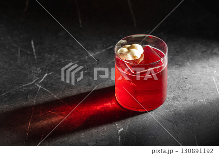 Red cocktail with ice and chocolate in spotlight 130891192