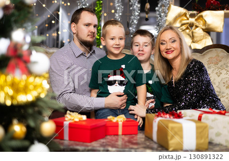 Family with mom and dad celebrates Christmas at home Family with mom and dad celebrates Christmas at home 130891322