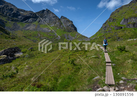 Woman On Kvalvika Beach Trail Near Fredvang On Lofoten Islands In Norway Woman On Kvalvika Beach Trail Near Fredvang On Lofoten Islands In Norway 130891556