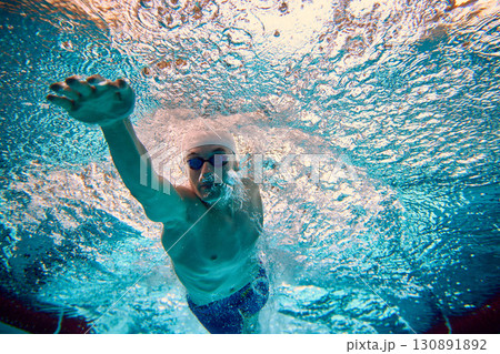 Underwater male swimmer front crawl stroke in dynamic motion Underwater male swimmer front crawl stroke in dynamic motion 130891892