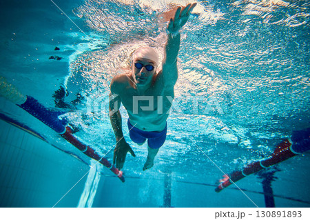 Competitive swimmer gliding underwater in freestyle with determination Competitive swimmer gliding underwater in freestyle with determination 130891893