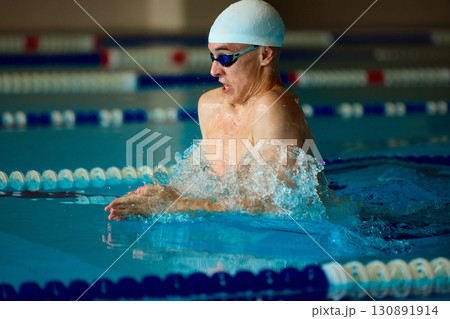 Male swimmer breaststroke push emerging from water in training pool Male swimmer breaststroke push emerging from water in training pool 130891914
