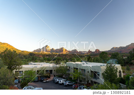 Sedona red rocks glowing at sunset over town buildings in Arizona 130892181
