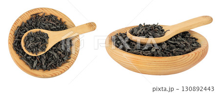 Dry black tea leaves in wooden bowl and spoon isolated on white background. Top view. Flat lay Dry black tea leaves in wooden bowl and spoon isolated on white background. Top view. Flat lay 130892443