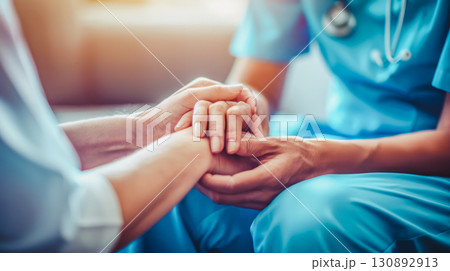 Healthcare worker holding patient's hands, symbolizing compassion, care, and support in medical setting. Perfect for promoting healthcare services, patient care, and importance of empathy in medicine 130892913