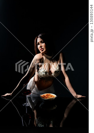 Spaghetti meal with a stylish woman in a studio setting at night 130893144