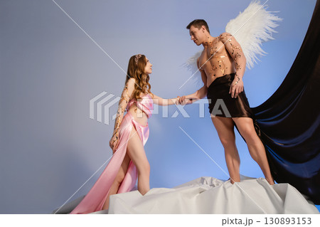 Couple in fantasy attire posing together on a creative stage setting Couple in fantasy attire posing together on a creative stage setting 130893153
