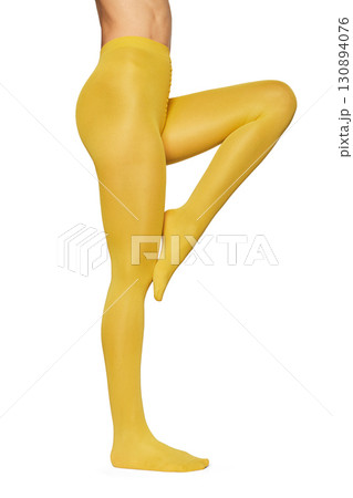 Beautiful long fit female legs in yellow tights on white background Beautiful long fit female legs in yellow tights on white background 130894076
