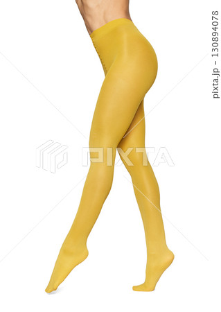 Beautiful long fit female legs in yellow tights on white background Beautiful long fit female legs in yellow tights on white background 130894078