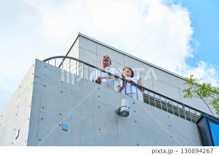 ベランダに立つ資産家熟年夫婦 ベランダに立つ資産家熟年夫婦 130894267