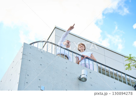ベランダに立つ資産家熟年夫婦 130894278