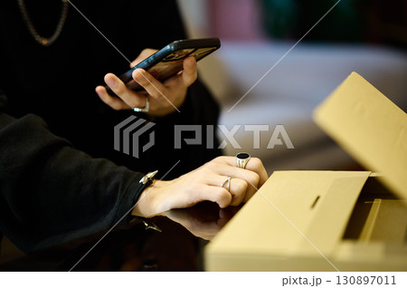 荷物の前でスマホを操作するZ世代の男性 130897011