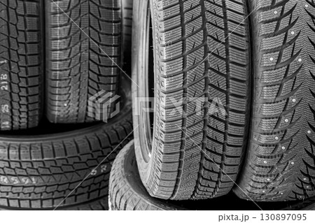Close-up of stacked car tires with detailed tread patterns for winter and all-season driving safety 130897095