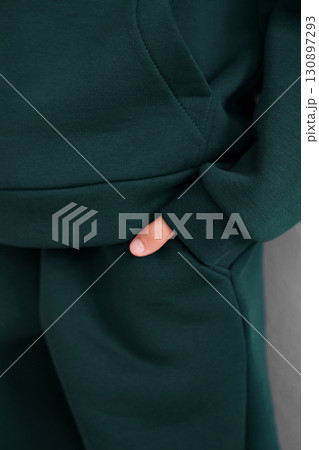 Green hoodie with pocket and cuff. Close-up of a warm tracksuit sleeve. Green hoodie with pocket and cuff. Close-up of a warm tracksuit sleeve. 130897293