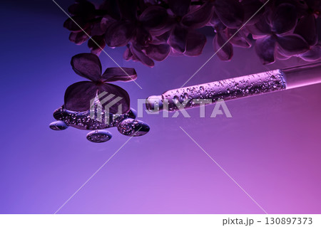 Cosmetic pipette with serum and lilac flowers. 130897373