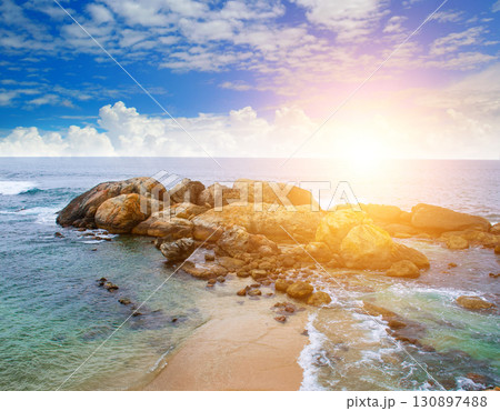 Sunrise over a rocky beach on a beautiful coastline. 130897488