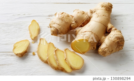 Fresh ginger root with sliced pieces on a rustic wooden background 130898294