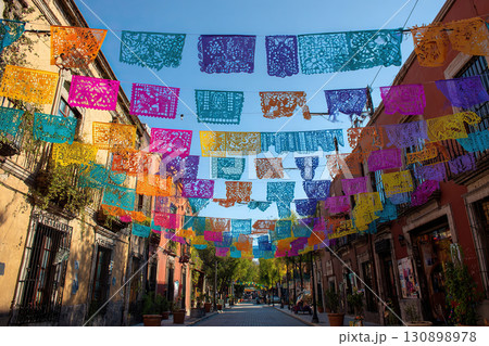 Mexican street decoration. Paper picados of different colors for the Day of the Dead celebration. 130898978
