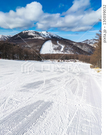 滑走跡と圧雪模様が残る冬のゲレンデと湯ノ丸山の景色 (長野県/東御市、群馬県/嬬恋村、湯の丸高原) 130899032